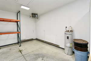Garage featuring secured water heater and a heating unit