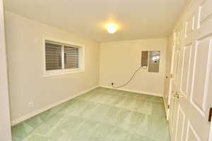 Unfurnished room featuring electric panel and light colored carpet