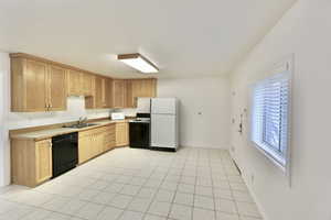 Kitchen with light countertops and light tile floors