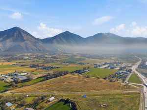 Aerial view of sparsely populated area featuring a mountain backdrop and extensive farmland