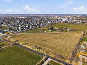 Aerial view of property and surrounding area featuring nearby suburban area