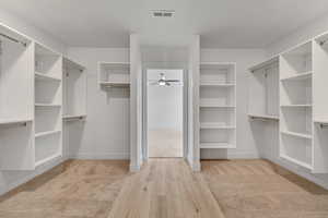 Walk in closet featuring light wood finished floors and ceiling fan
