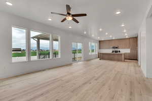 Unfurnished living room featuring a mountain view, light wood-style floors, ceiling fan, and recessed lighting