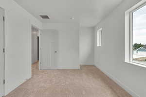 Empty room featuring light colored carpet and baseboards