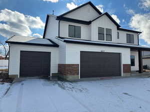 View of front of home featuring brick siding and board and batten siding