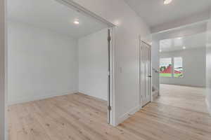 Hall featuring light wood finished floors and recessed lighting
