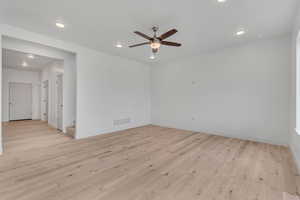 Unfurnished room with light wood-type flooring, recessed lighting, ceiling fan, and stairway