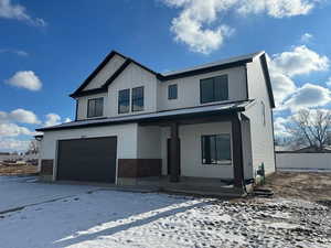 Modern farmhouse style home with a garage, a porch, and brick siding
