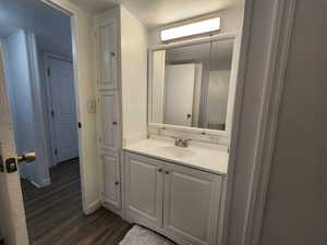 Bathroom with vanity, dark wood finished floors, and a textured ceiling