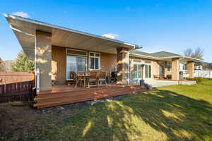 Rear view of property featuring outdoor dining area, a deck, stucco siding, and a patio