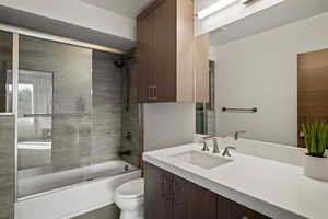 Bathroom featuring shower / bath combination with glass door and vanity