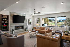 Living area with wood finished floors, a fireplace, recessed lighting, and a ceiling fan