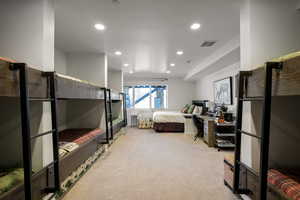 Bedroom with light colored carpet and recessed lighting