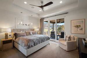 Bedroom featuring a tray ceiling, access to outside, carpet floors, recessed lighting, and a ceiling fan