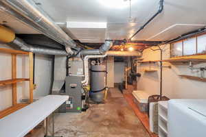 Unfinished basement with washer / dryer, water heater, and heating unit