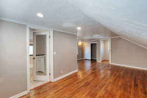 bedroom featuring a textured ceiling, light wood finished floors, vaulted ceiling, and recessed lighting