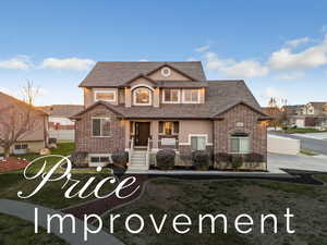 View of front of house with a porch, brick siding, stucco siding, and a shingled roof