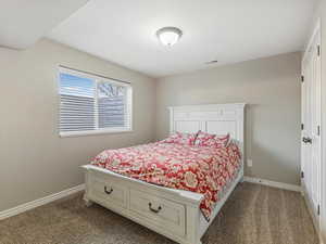 Bedroom featuring baseboards and dark carpet