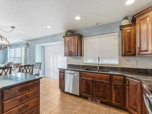 Kitchen with stainless steel appliances, dark stone countertops, decorative backsplash, recessed lighting, and light tile patterned flooring