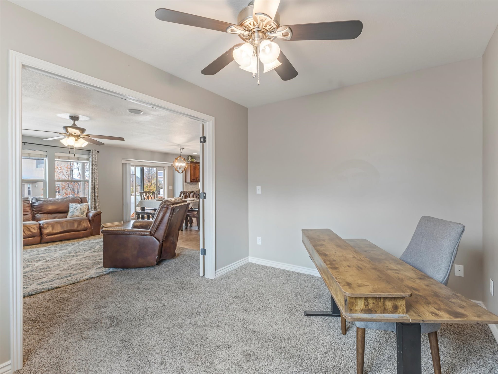 Office area with light carpet and a ceiling fan