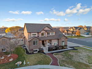 View of front of property with covered porch, a front lawn, brick siding, and a residential view