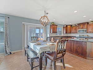 Dining room with a chandelier, light tile patterned flooring, and recessed lighting