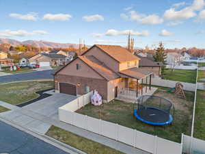 View of front of property with a residential view, a fenced backyard, a patio, a playground, and a trampoline
