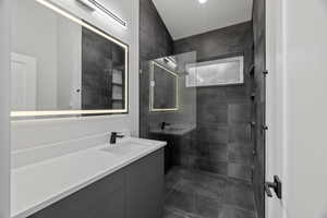 Bathroom featuring walk in shower and vanity