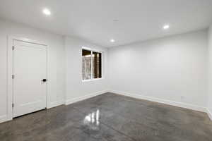 Empty room with concrete flooring and recessed lighting
