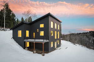 Snow covered house with a wooden deck
