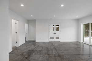 Spare room with finished concrete flooring, french doors, and recessed lighting