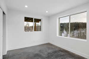 Unfurnished bedroom with a closet, concrete flooring, and recessed lighting
