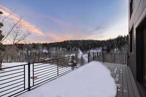 Snowy yard featuring a wooden deck