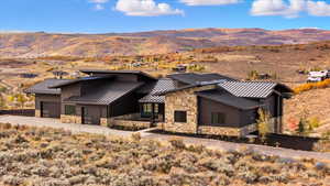 View of front of property with a metal roof, stone siding, and a mountain view