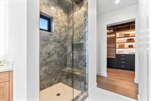 Full bath with a marble finish shower, tile patterned floors, vanity, and recessed lighting