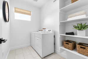 Laundry room featuring washer and dryer and light tile patterned floors