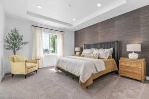 Carpeted bedroom with an accent wall, wood walls, a tray ceiling, and recessed lighting
