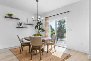 Dining area featuring light wood-type flooring and a chandelier