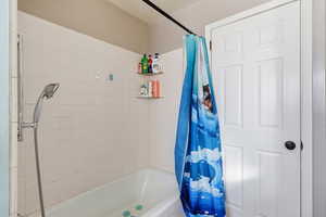Full bathroom featuring shower / bathtub combination with curtain