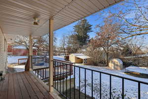 Snow covered deck with a shed