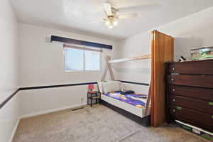 Bedroom featuring light carpet, a ceiling fan, and a textured ceiling