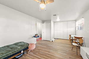 Sitting room with light wood-style flooring and ceiling fan