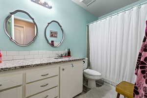 Full bath with vanity and a textured wall