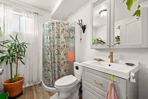 Bathroom with a stall shower, vanity, and light wood-type flooring