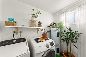 Laundry room with water heater and separate washer and dryer