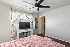 Bedroom featuring dark wood-type flooring and a ceiling fan