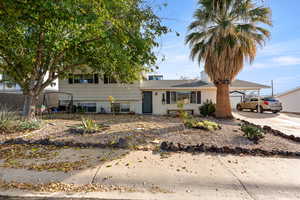 Split level home featuring a carport, concrete driveway, and brick siding