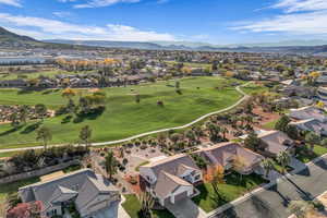 Aerial view of residential area with a mountainous background and a local golf course