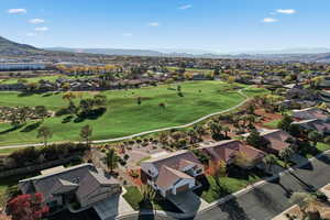 Aerial perspective of suburban area featuring a mountainous background and a golf course
