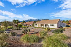 Back of house with a patio area and a mountain view